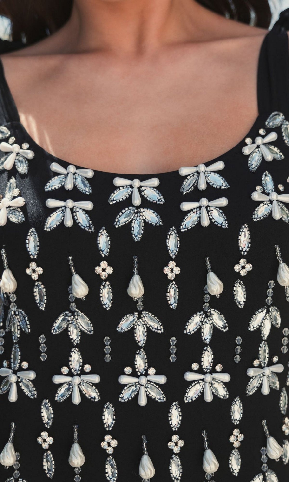 Close-up of the Short Wedding Guest Dress 10937 by Mac Duggal—a black sleeveless top adorned with pearl and gem embellishments in symmetrical patterns, perfect for a chic black-tie event.